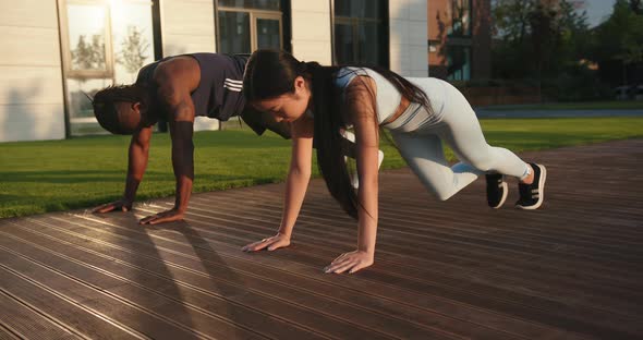 Asian Woman and Black Guy Do Exercises and Give Five