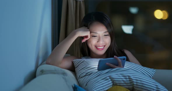 Woman watch on mobile phone at night