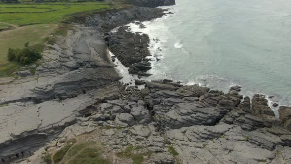 Aerial top view of waves break on rocks in a blue ocean. Sea waves on beautiful beach aerial view dr