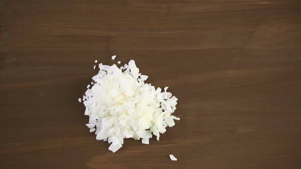 Dehydrated coconut flakes on a wood background