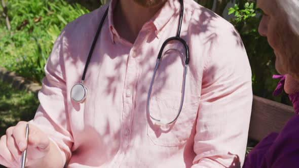 Doctor with a senior woman in the park of a retirement home