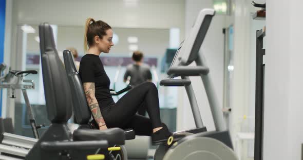 Woman Exercising with Elliptical Cross Trainer at gym.Side View, Slow Motion. Woman Training at