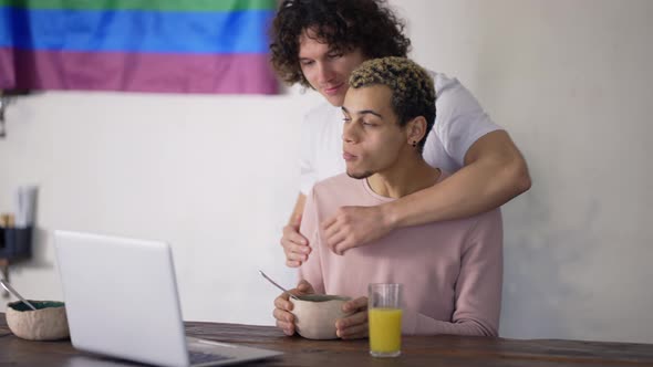 Couple Gay Hugging on the Kitchen During One is Eating