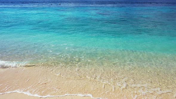 Wide flying abstract view of a sunshine white sandy paradise beach and blue water background in vibr