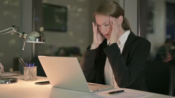 Businesswoman Having Headache While Working on Laptop at Night