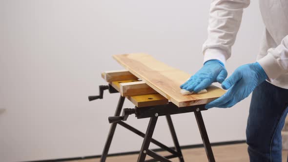 the Carpenter Covers the Wood with Oil with a Napkin