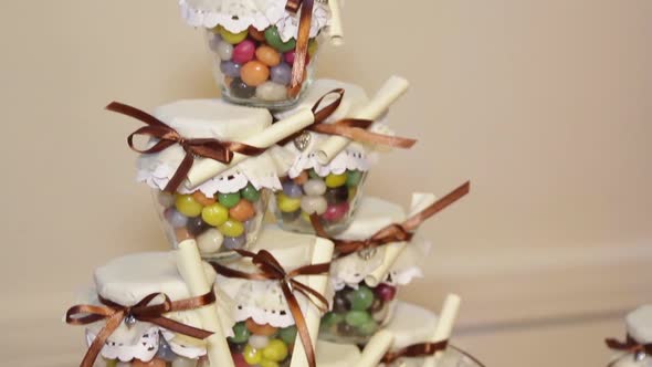 Multicolored Candies in Glass Jars for Guests of Wedding Party.