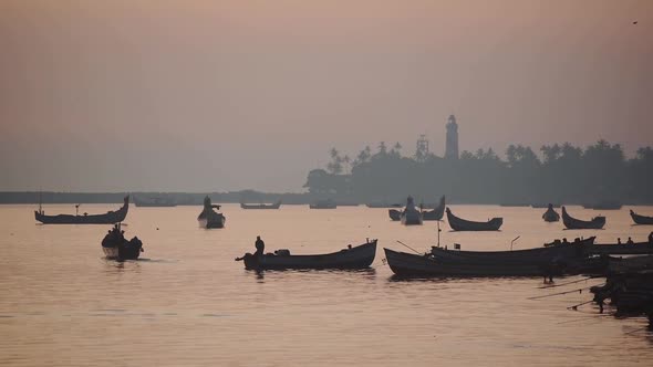 Landscape view of silhouettes of fishermen going fishing on their traditional boats, Kappil Beach, V