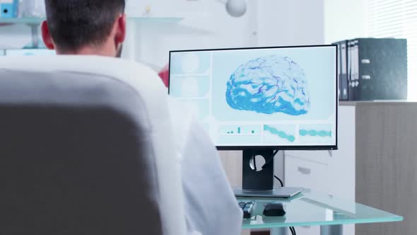 Doctor in Modern Research Center Looks at 3D Brain Scan