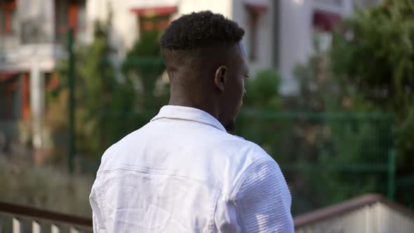 Live Camera Panning Left to Right Around Relaxed African American Man Standing Outdoors and Posing