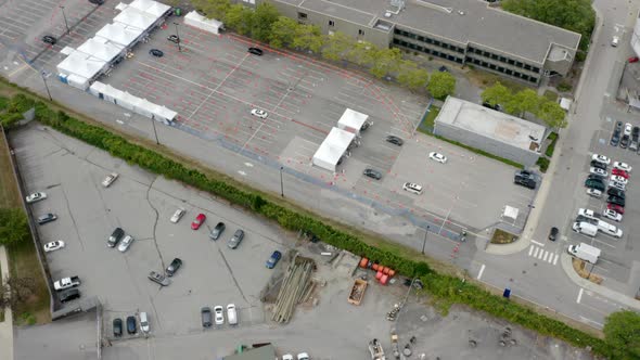 Cars Lined Up In Queue At Covid-19 Drive-Thru Testing And Vaccine Site At Daytime. aerial