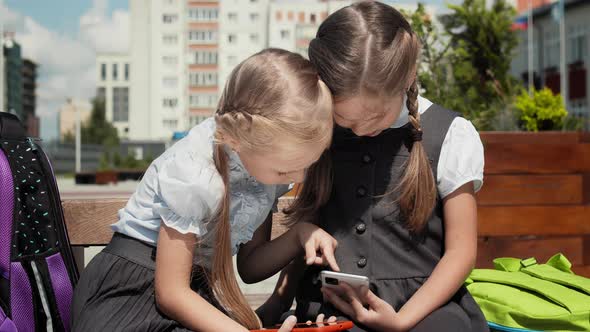 Children Play With Mobile Phone In Schoolyard