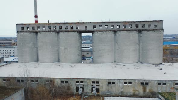 old abandoned factory with concrete pipes and broken windows. Aerial view.