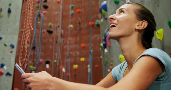 Woman using mobile phone in bouldering gym 4k