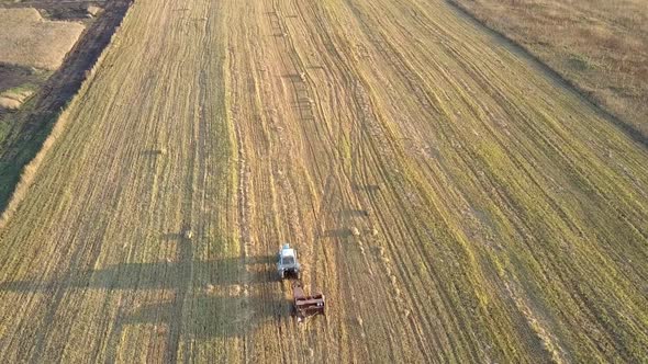 Upper View Square Baler Collects Straw on Harvested Field