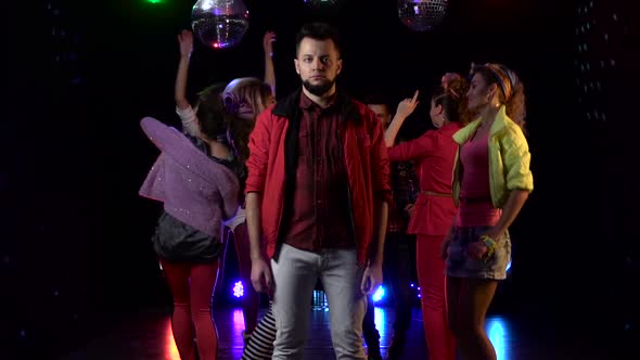 Guy Stands in Sadness Around a Crowd of Cheerful People Dancing in Their Disco . Black Background