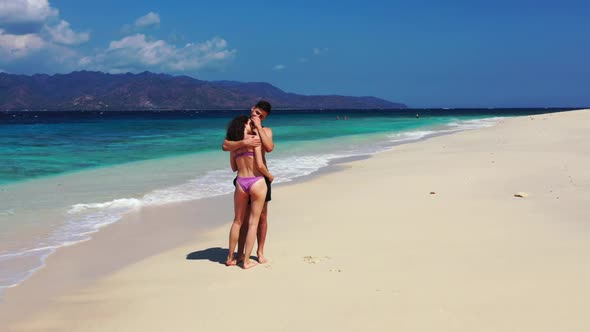 Romantic couple posing on marine seashore beach lifestyle by clear lagoon and white sandy background