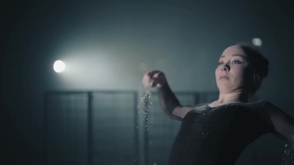 Portrait of Professional Ballerina Dancing in Black Dress in the Studio in Spotlight on Black