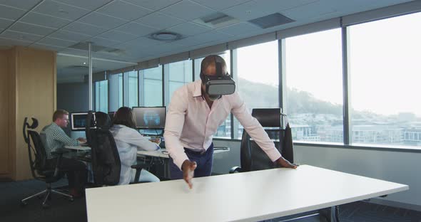 African American businessman wearing VR headset in modern office