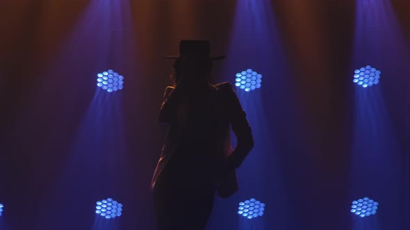 Silhouette of Attractive Woman in Pantsuit and Hat Performing an Argentinean Flamenco Dance