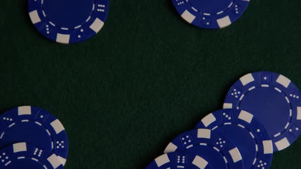 Rotating shot of poker cards and poker chips on a green felt surface - POKER 035