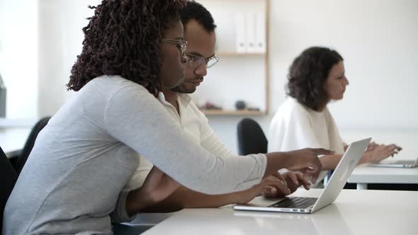 Side View of Concentrated Employees Working with Laptop