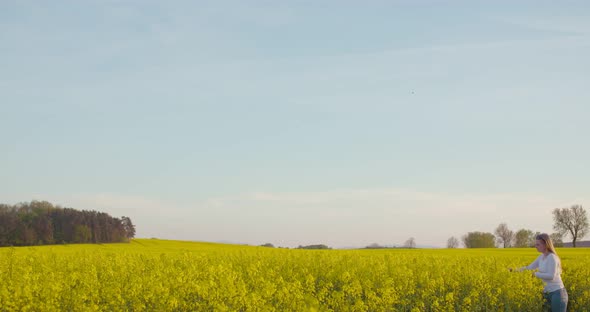 Female Farmer Examining Oilseed Rape Field