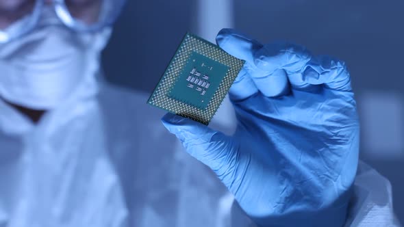 Man in clean room holds up computer cpu microchip