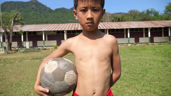 Rural Boy Holding A Old Ball