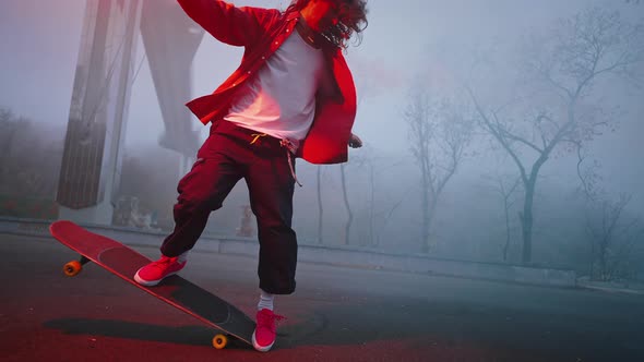 Skater Performs a Tail Turn Trick While Holding a Torch in One Hand