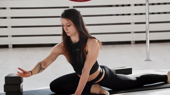 Fitness  a Young Woman Gymnast Stretching on the Floor in White Studio