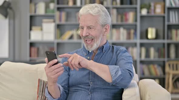 Old Man Celebrating Success on Smartphone