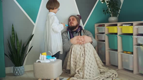 Father and Child Playing Clinic and Doctor Little Boy in Medical Gown with Stethoscope Play an
