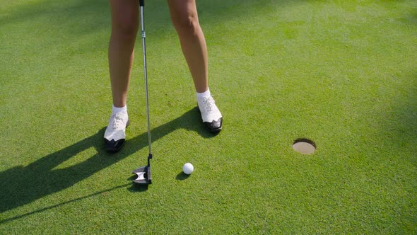 Green Park Woman Playing Golf Hits the Ball in the Hole View of the Legs From the Lower Angle Golf