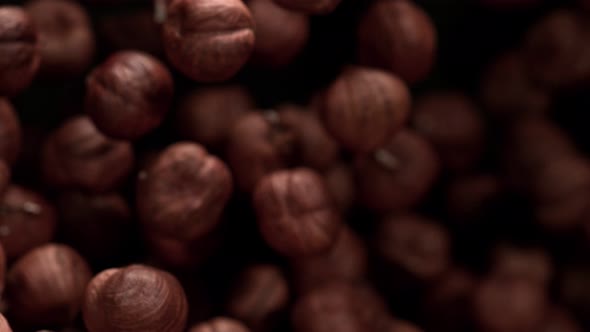 Super Slow Motion Shot of Hazelnuts Flies After Being Exploded Against Black Background 1000Fps