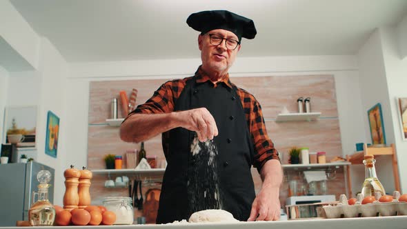 Adding Flour on Dough By Hand Looking at Camera