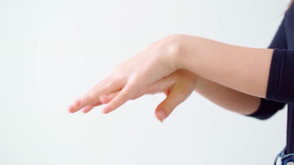 Female Applying Hand Cream Against White Background Close Up