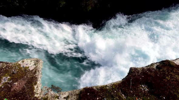 Turbulent whitewater passing through a narrow passage on the Waikato River at Huka Falls in Taupo, N
