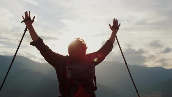 Joyful Hiker Raise Hands to Mountains Sky