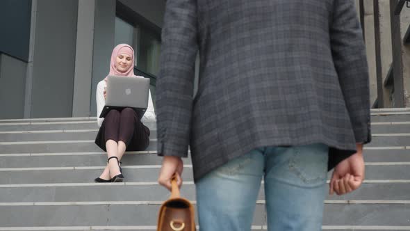 Smiling Woman in Hijab and Formal Wear Sitting with Modern Laptop on Knees
