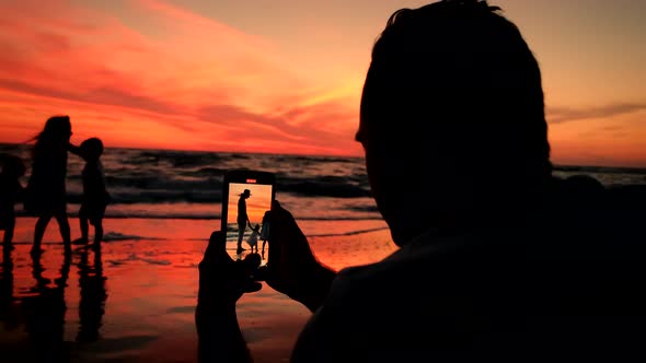 Family Taking Pictures at Sunset