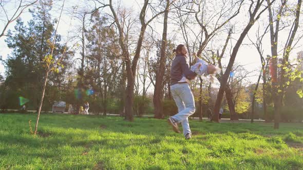 Young Father Having Fun with His Little Daughter in Park Slow Motion