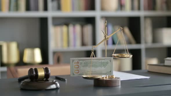 Close Up Shoot of Scale Holding Money with Gravel on Court Desk