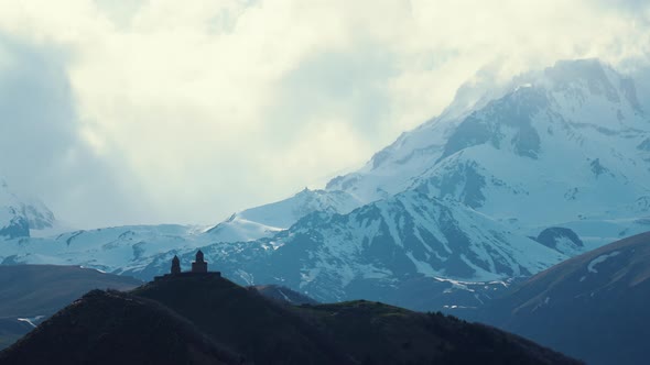 Great Caucasus Mountains and Ancient Gergeti Trinity Church in Kazbegi Georgia alt