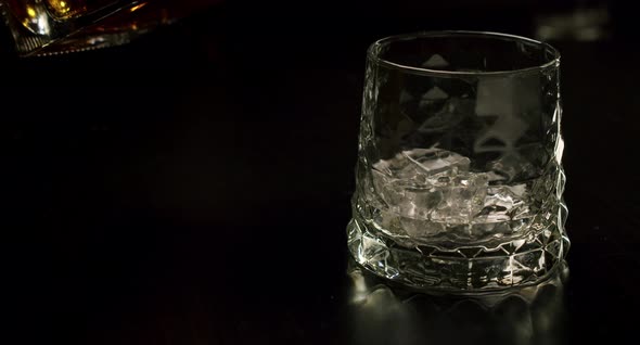 Slow Motion Golden Whiskey Pouring Glass Ice Cubes From Bottle