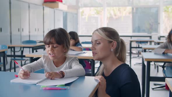 Primary School Teacher Helping Latin Schoolgirl