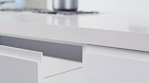 Close up of a white modern luxury kitchen drawer closing slowly