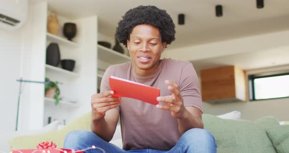 African american man opening gift at home