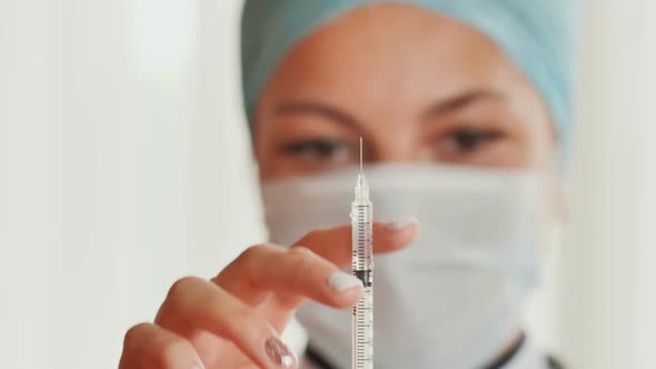 A Woman Doctor Prepares a Syringe for a Shot