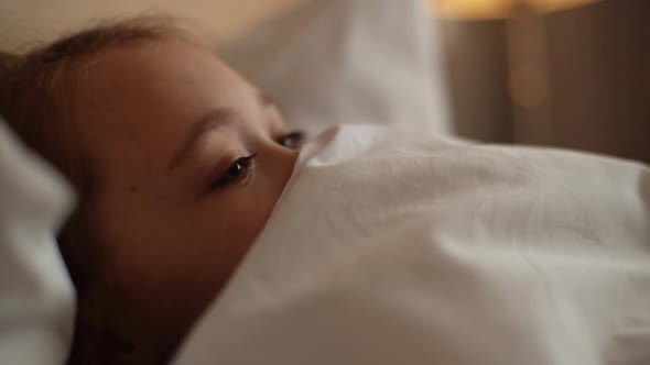 Closeup Face of Little Tired Girl Falling Asleep in Home Under Blanket Blinking Eyes Slowly Head